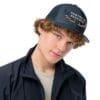 Here's an 8-word alt tag for the image: Man wearing navy hunting is patriotic hat.