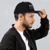 Man wearing a black Pissed Red hat.