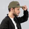Man wearing a green Pissed Bed trucker hat.